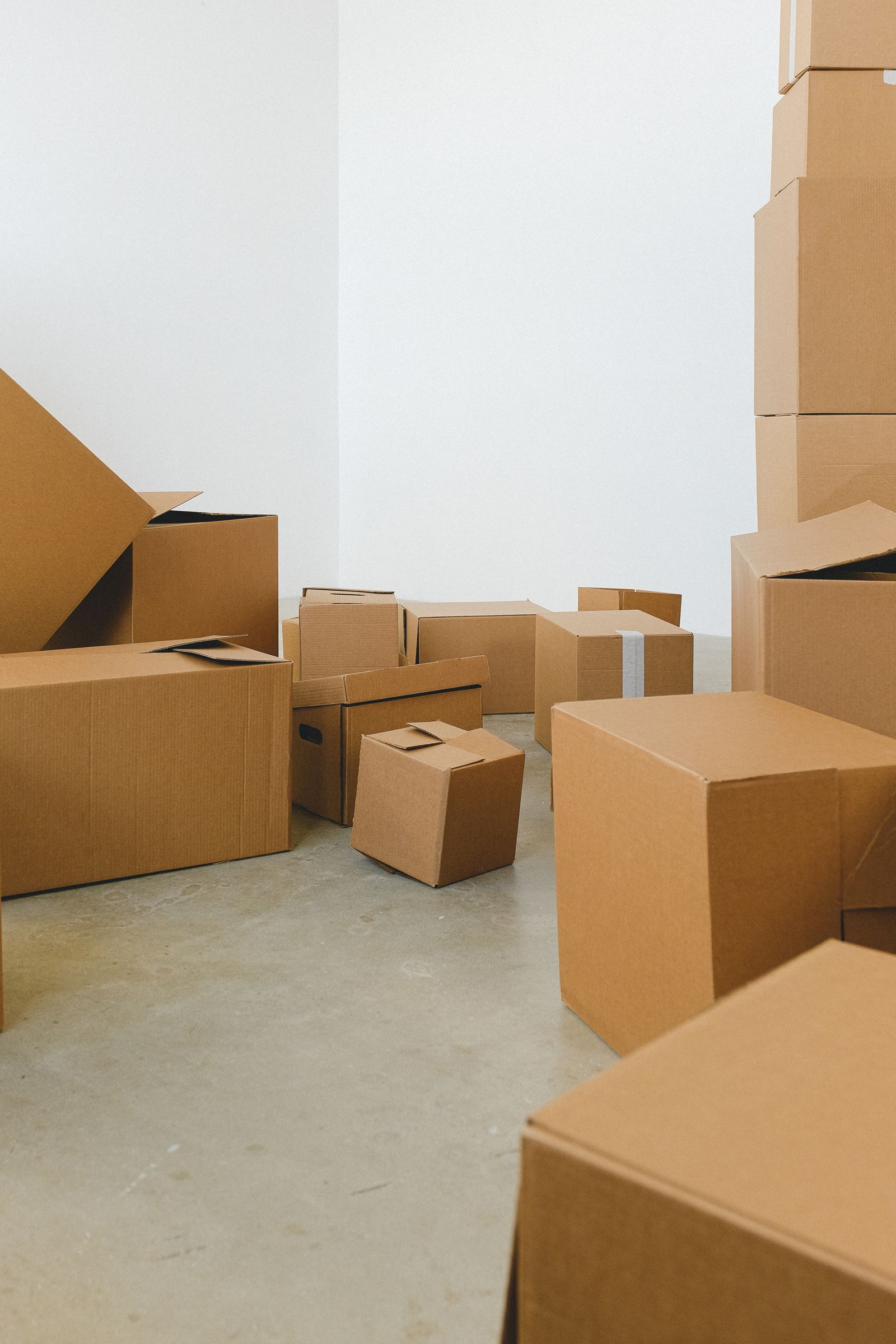 Stacks of cardboard moving boxes on the floor of a house being packed