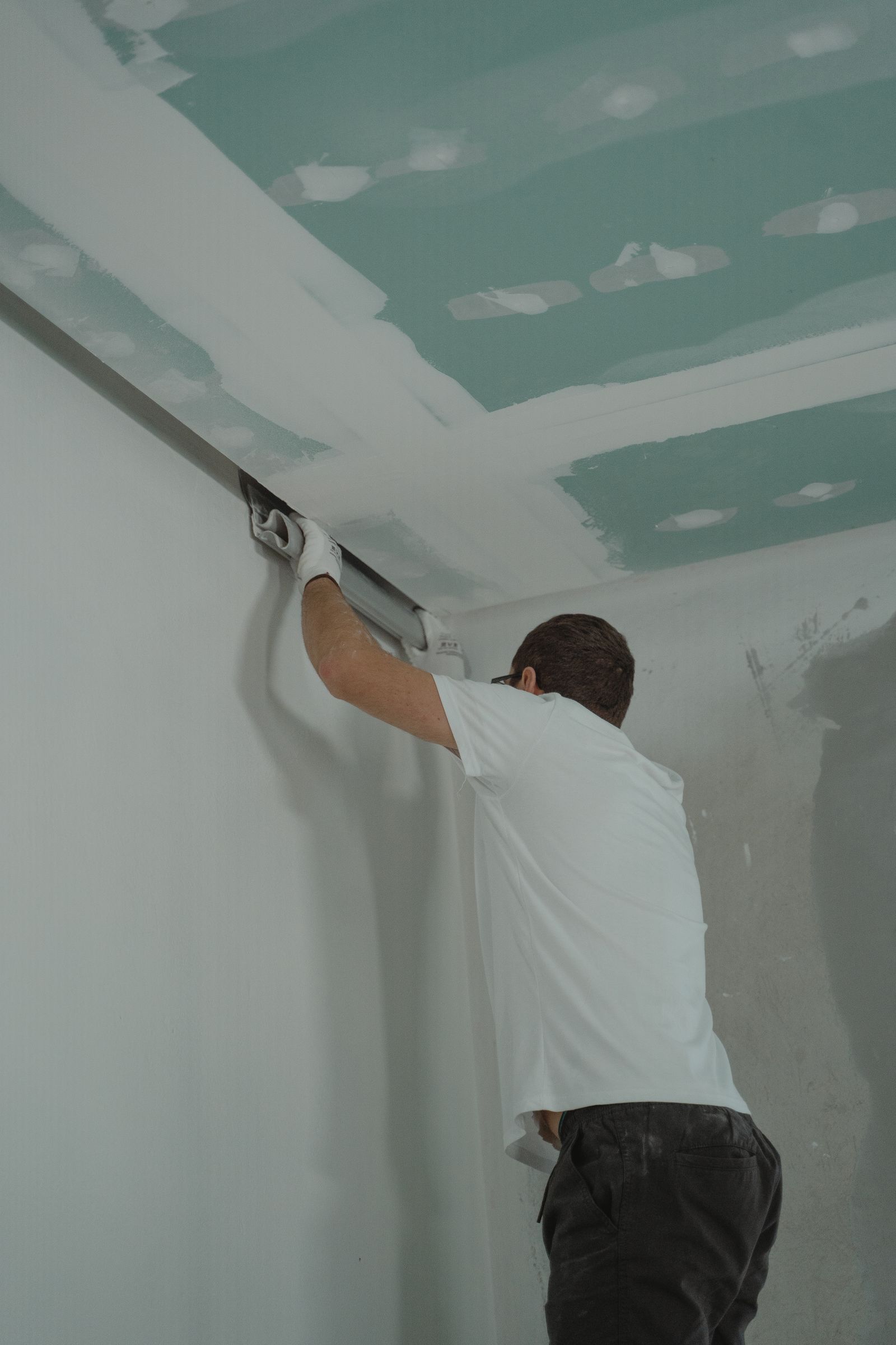 A worker installing drywall during a home renovation